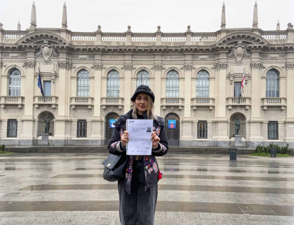 Melika holding her ielts exam in front of a building